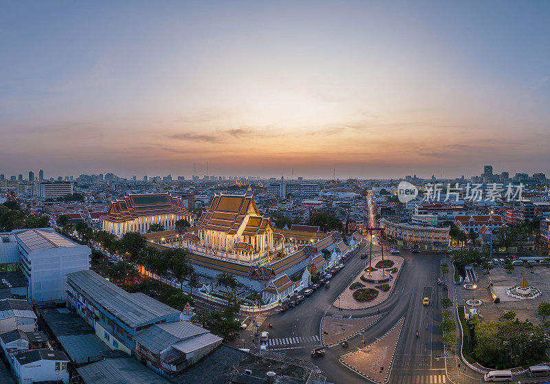 空中无人机俯瞰泰国曼谷的Suthat Thepwararam(Suthat Thepwararam寺)和Giant Swing (Sao Chingcha)，这是一个著名的旅游地标，黄昏时分，车辆和游客沿着街道通勤。Bangko